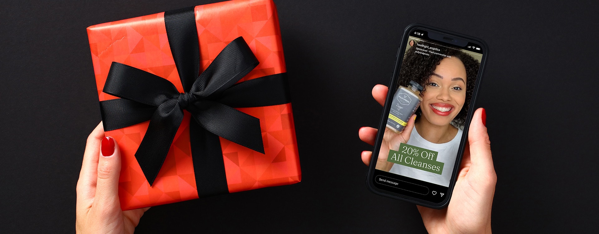 A gift in the left hand with a phone in the right hand.