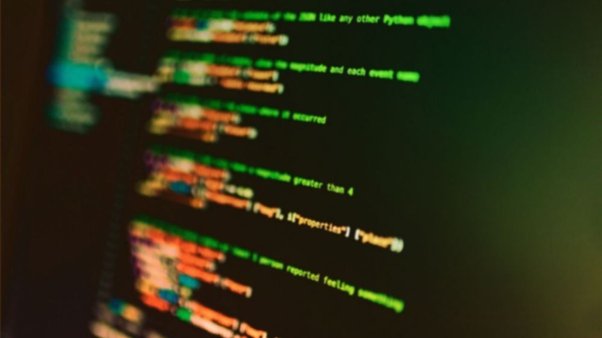 Colourful lines of code on a dark screen, partially blurred with green and orange text.