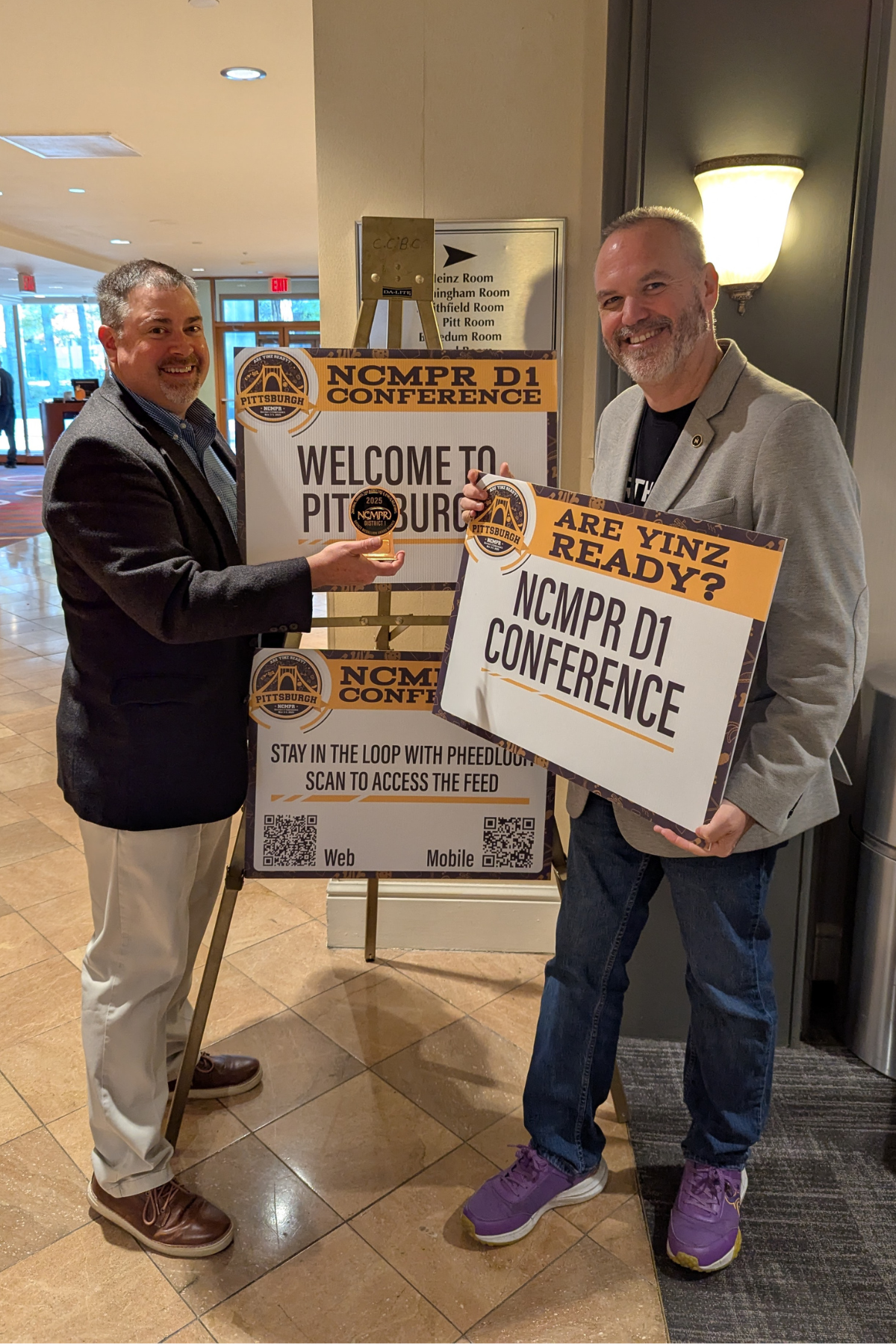 Jay Menard of Northern holding a humorous 'Are Yinz Ready?' sign at the NCMPR conference in Pittsburgh