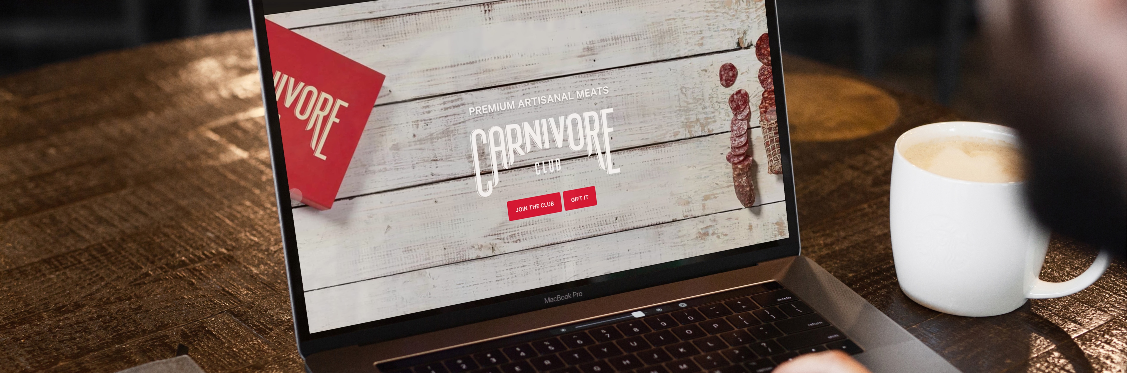 laptop on wood table showcasing the Carnivore Club website