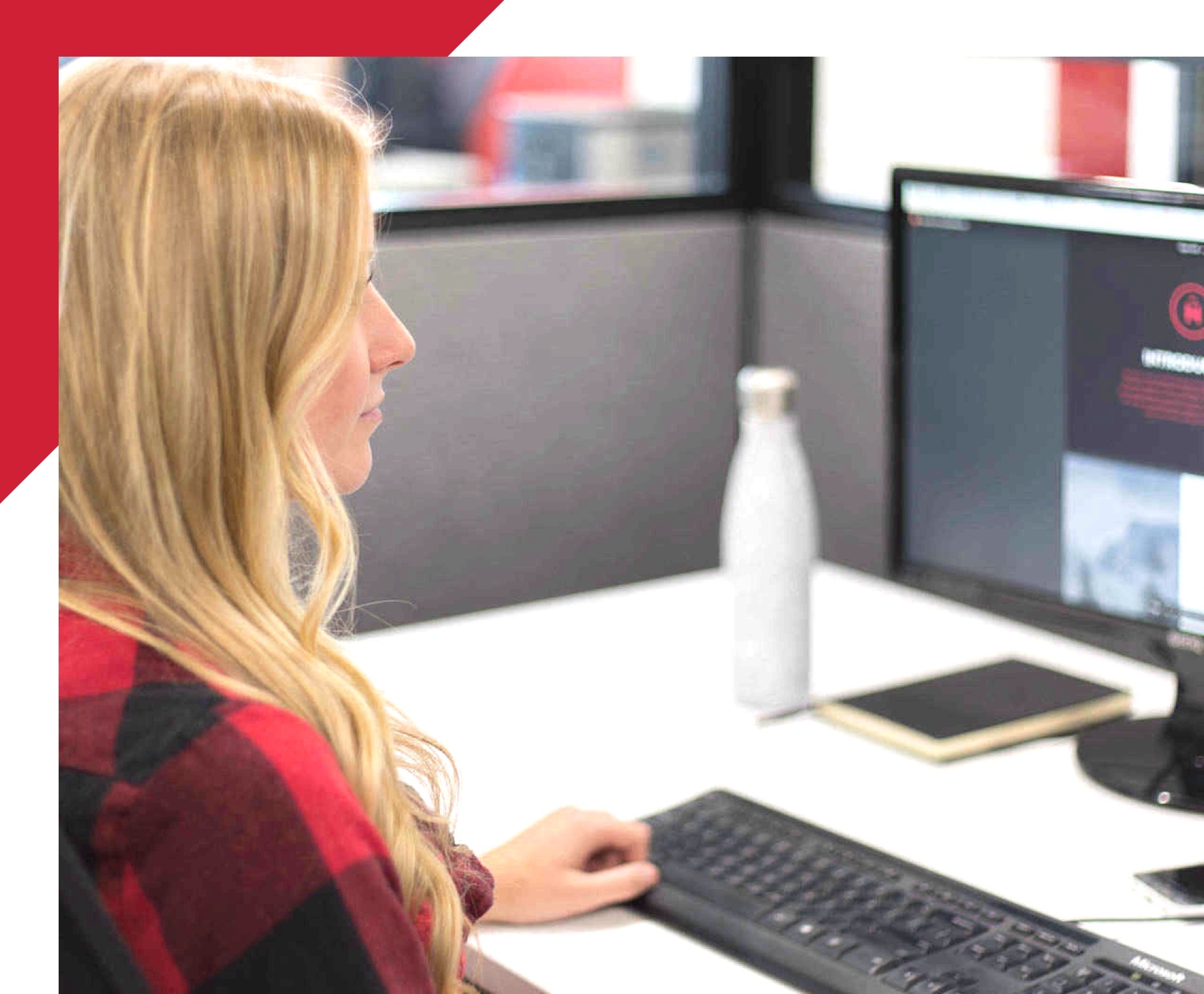 woman looking at computer screen in cubicle