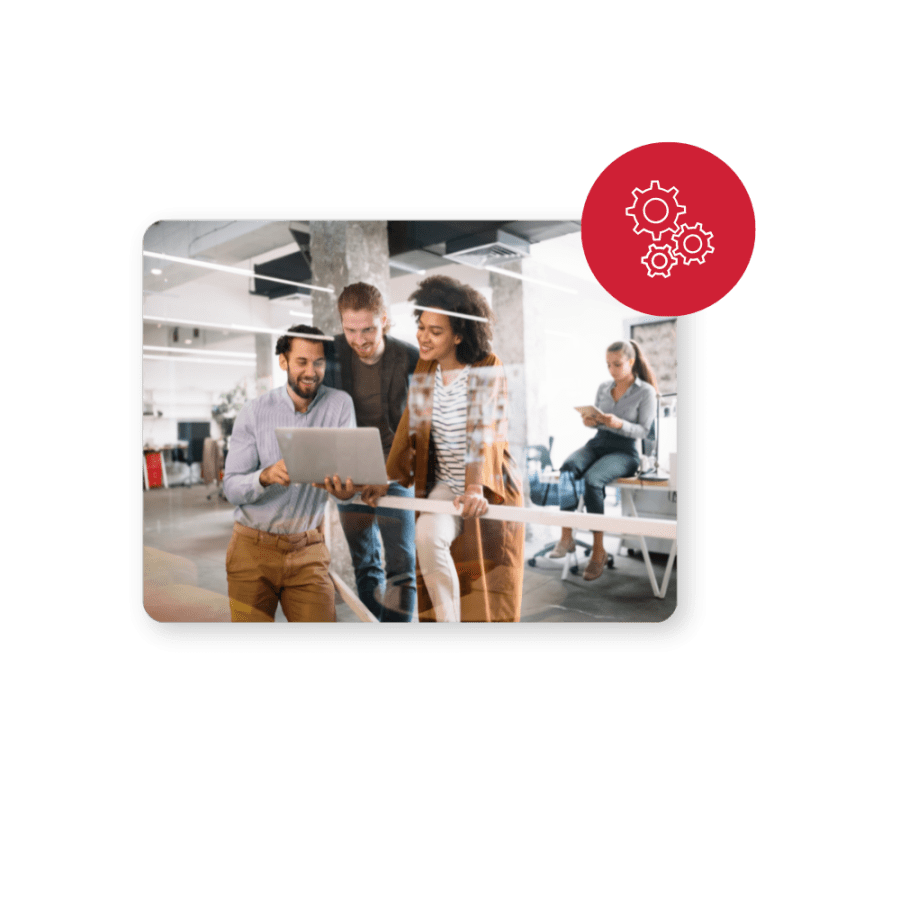 group of people gathered around a laptop with a gear logo in the top right corner