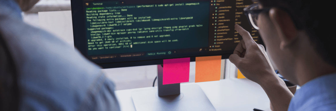 People looking at computer code on monitor