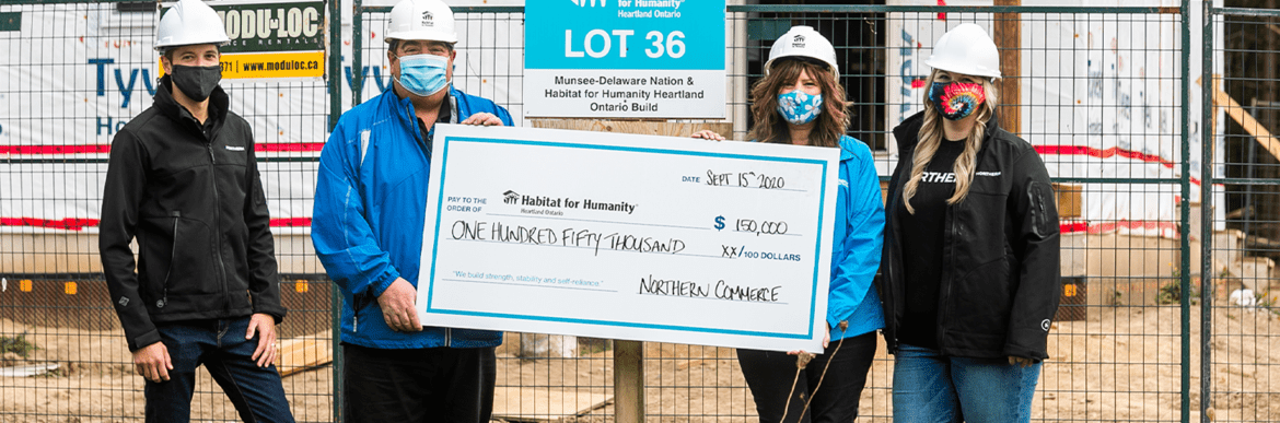Habitat for Humanity builders with large cheque