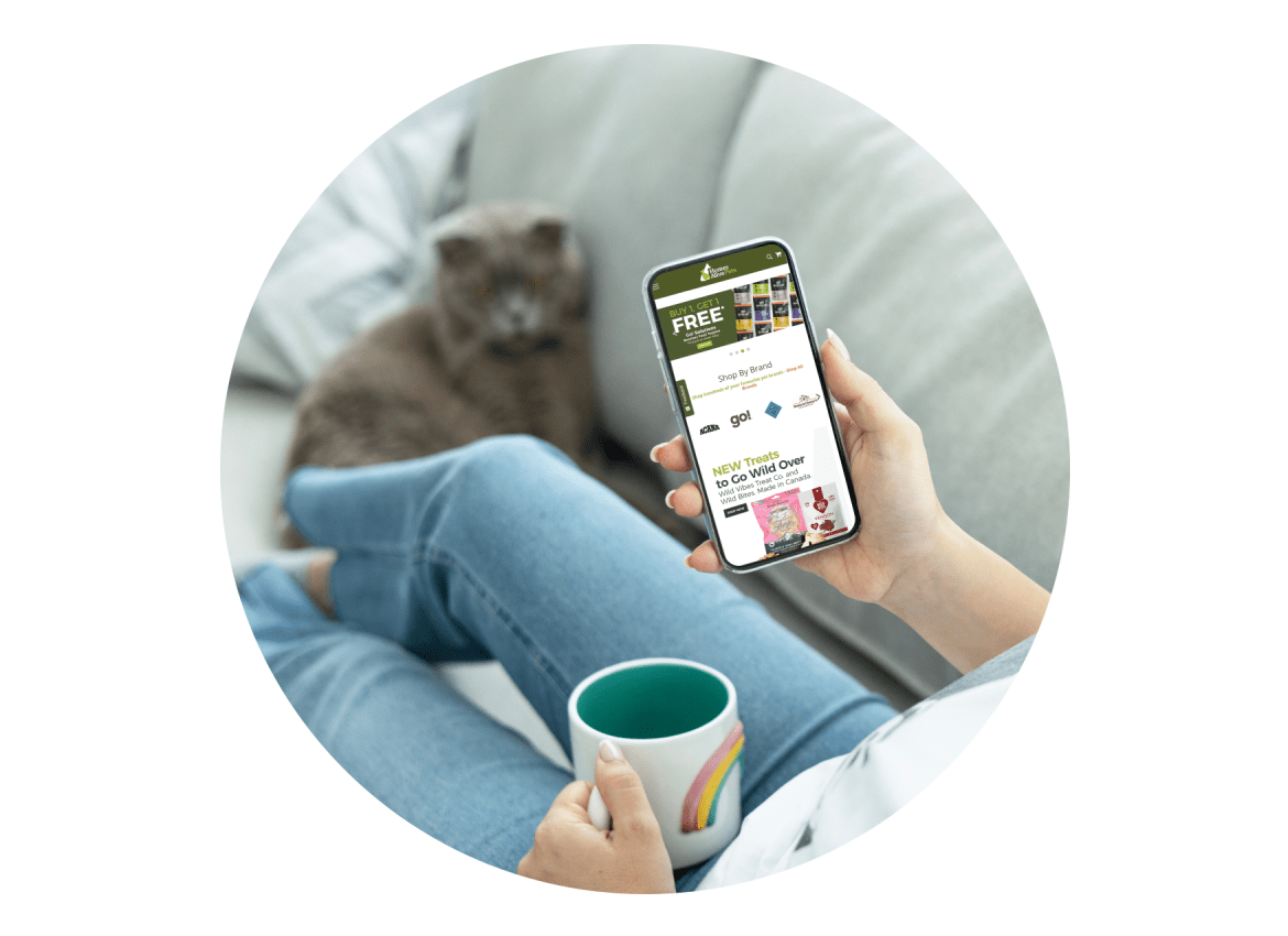 Woman laying on couch browsing Homes Alive Pets website on her mobile phone