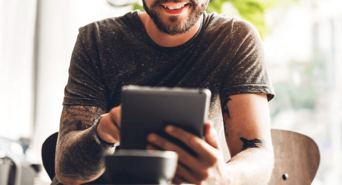 Man smiling and using a tablet