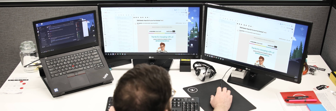 Man working at laptop with multiple screens