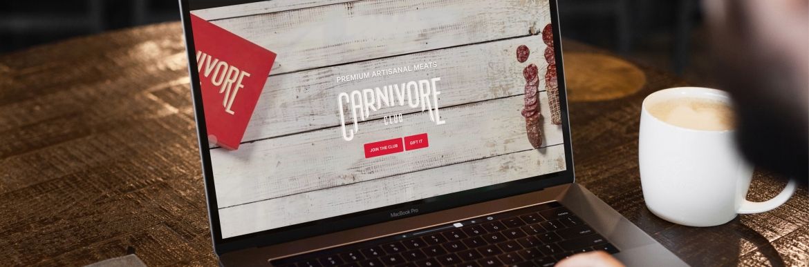 laptop on wood table showcasing the Carnivore Club website