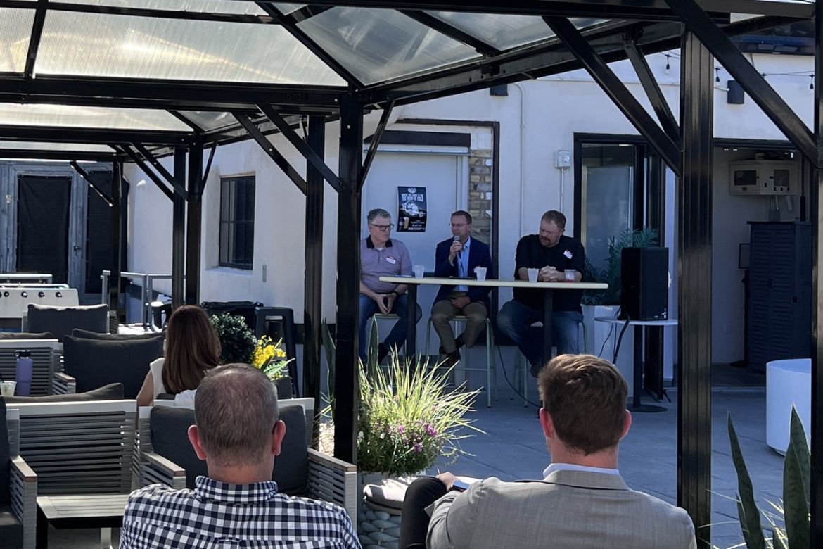 Guests on NOLO's rooftop in Minneapolis watching a three-person panel discussion on Customer Journey Analytics