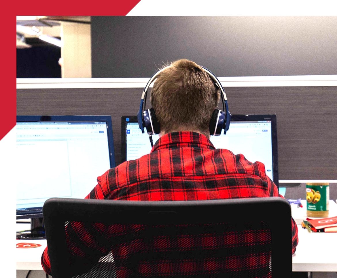 back view of a man working on dual monitors