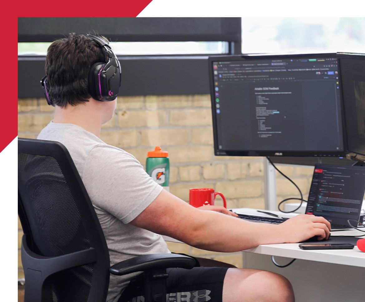 man working on computer with code on the monitor
