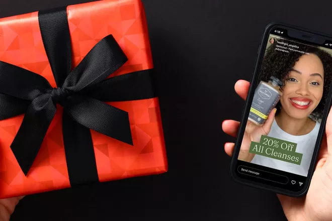 A gift in the left hand with a phone in the right hand.