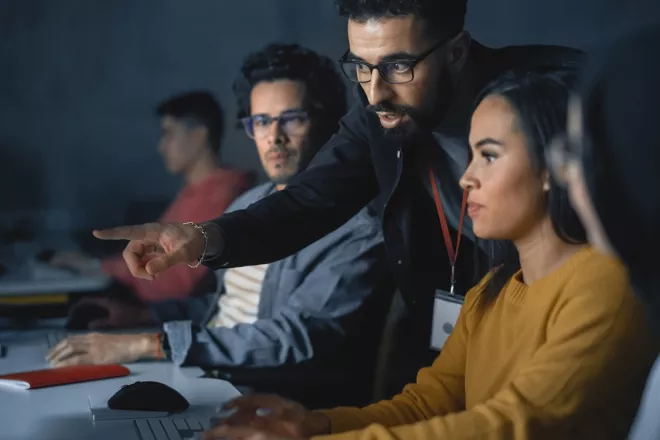 Teacher helps students with project and advising on their work.