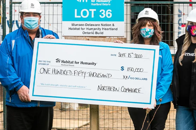 Habitat for Humanity builders with large cheque