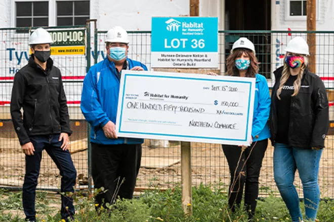Habitat for Humanity builders with large cheque