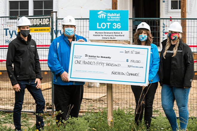 Habitat for Humanity builders with large cheque