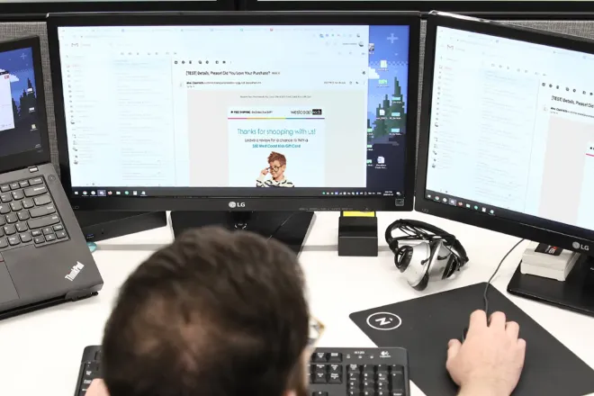 Man working at laptop with multiple screens