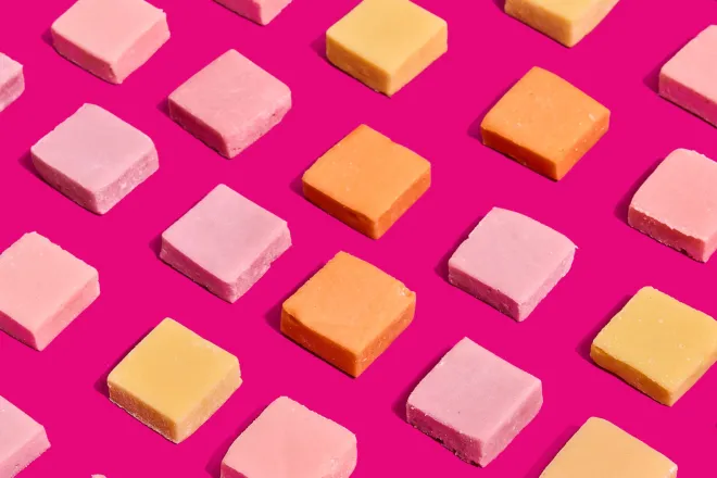 Protein Candy squares in rows on a pink background