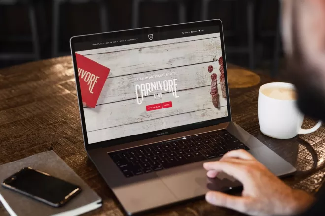 laptop on wood table showcasing the Carnivore Club website