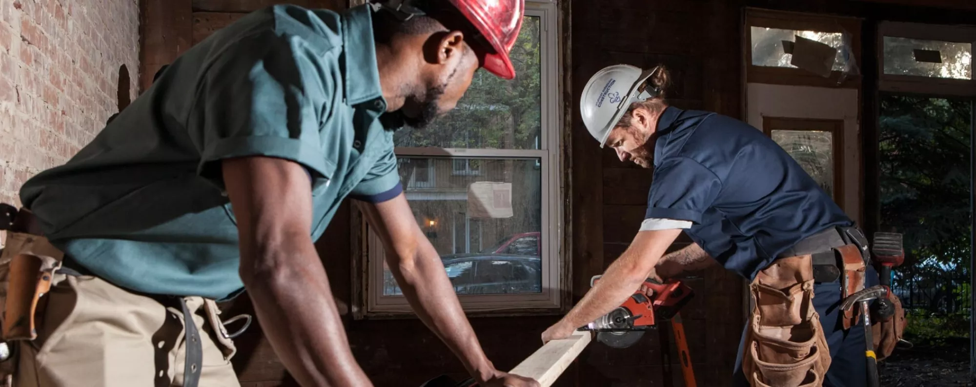 Woodworkers cutting a piece of wood