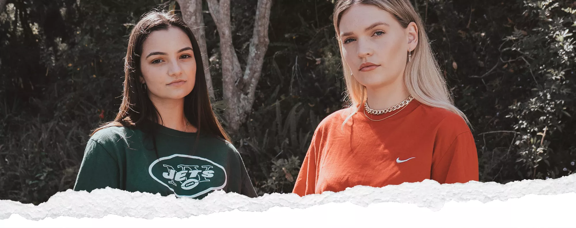 two teen girls models standing in front of a tree