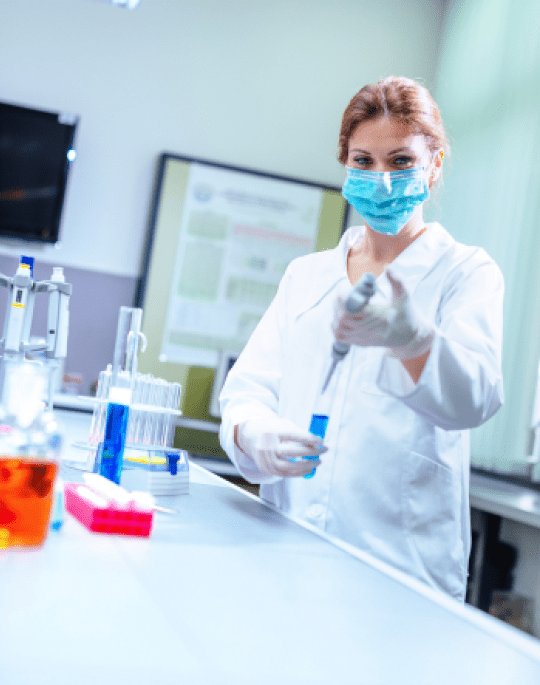 Lab technician behind a desk with a beaker on it