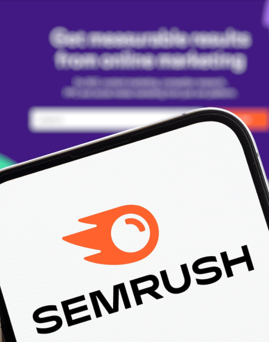 Semrush logo on a mobile device on top of the Semrush landing page.