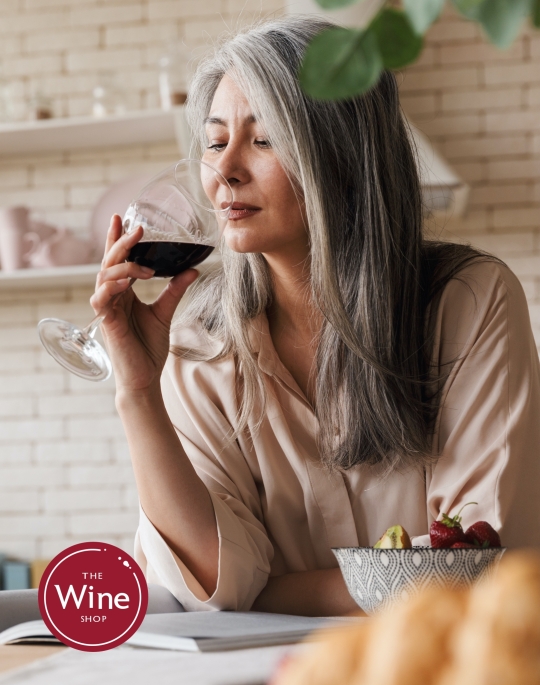 woman drinking wine leaning on a counter